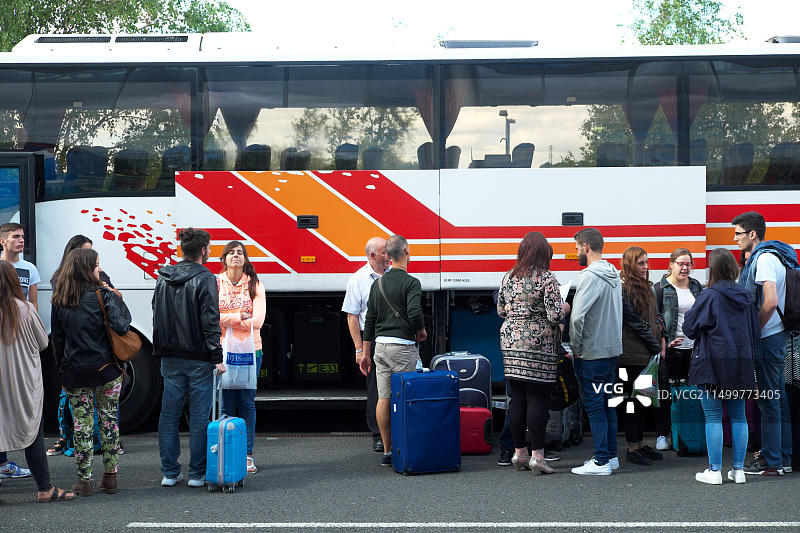在英国排队将行李装载到长途客车的乘客图片素材