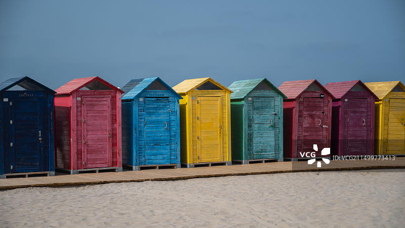 夏季彩色海滩小屋与蓝色天空背景图片素材