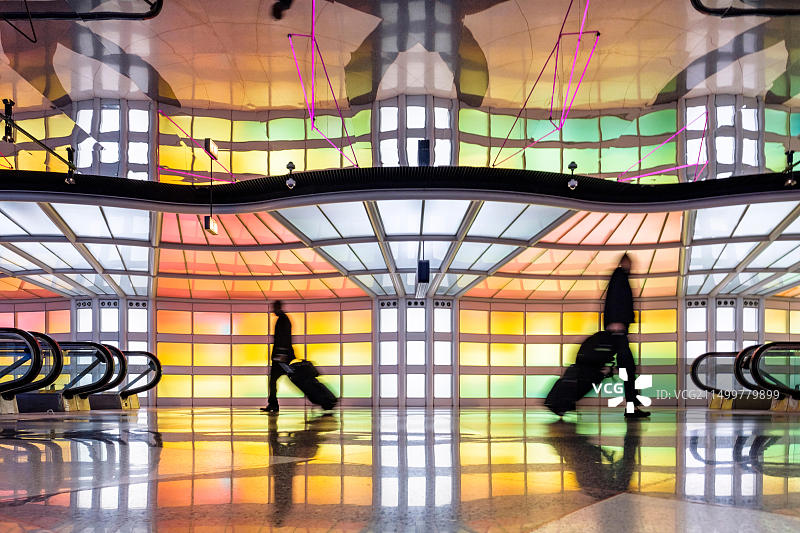 旅客，商务人士走动，迈克尔·海顿的彩色霓虹灯艺术装置，人行隧道，芝加哥奥黑尔机场航站楼图片素材
