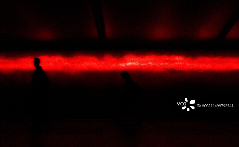 两人穿过底特律机场光隧道的红光图片素材