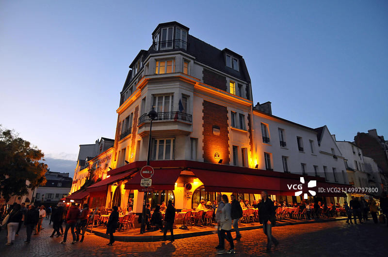黄昏时分，行人漫步在巴黎蒙马特区特尔特广场，广场两旁排列着咖啡馆，街头艺术家经常光顾图片素材