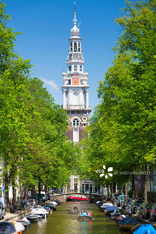 阿姆斯特丹旧城区南教堂和运河上的观光游船图片素材