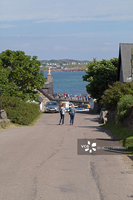 从女修道院俯瞰山丘，行人离开爱奥那岛，在地平线上乘坐渡轮前往马尔岛的Fionnphort，前往Port Ronain码头。图片素材