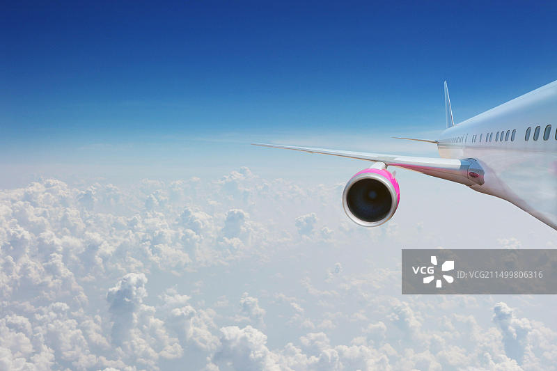 在云层上方高空飞行的飞机：交通运输、度假和旅行概念图片素材