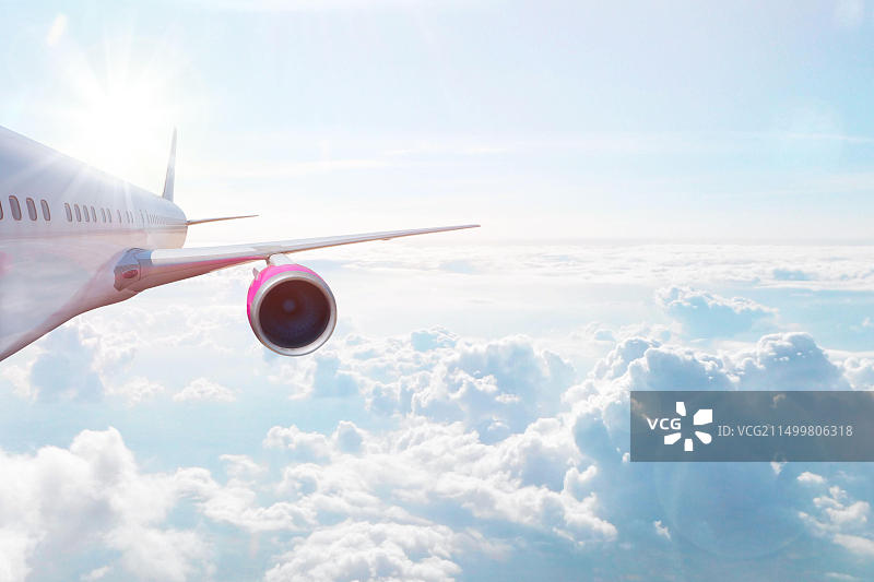 在云层上方高空飞行的飞机：交通运输、度假和旅行概念图片素材