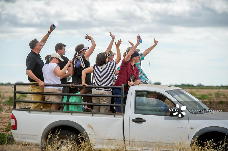 在南非，人们站在皮卡车后挥手图片素材