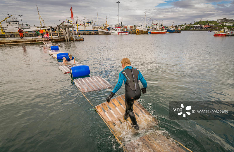 在冰岛哈夫纳夫约杜尔年度海员节上，男孩们乘坐木筏图片素材