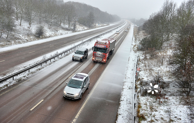 在英国什罗普郡一条被雪覆盖的高速公路上行驶的车辆图片素材