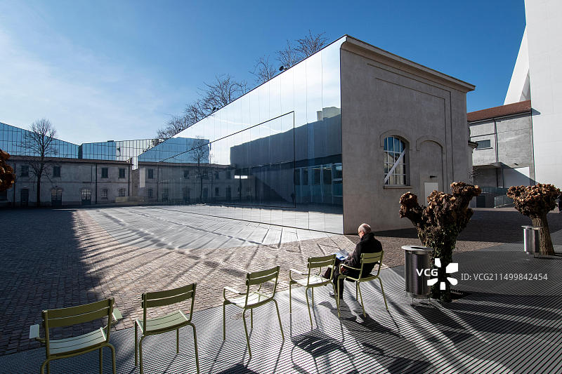 男人坐在米兰普拉达基金会庭院的椅子上图片素材