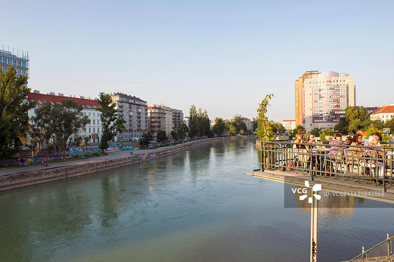 人们在奥地利维也纳多瑙运河Kylo咖啡馆的露台上放松身心图片素材