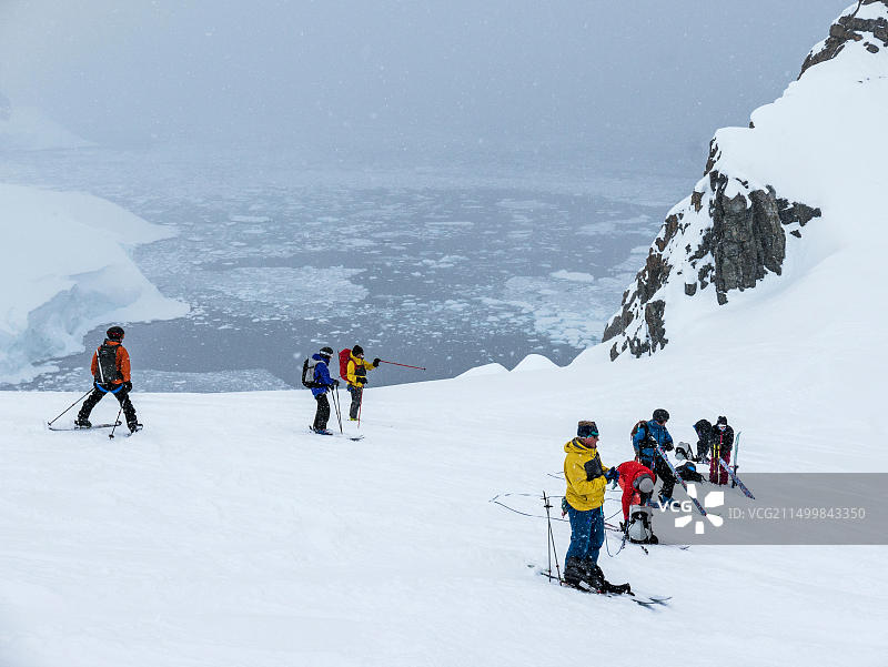 滑雪登山者用滑雪板上的合成皮绳索连接在一起，以防止冰裂缝，向上攀登；南极洲图片素材