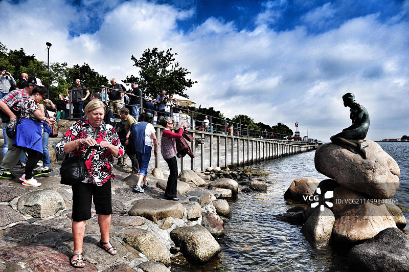 游客在丹麦哥本哈根拍摄小美人鱼雕像图片素材