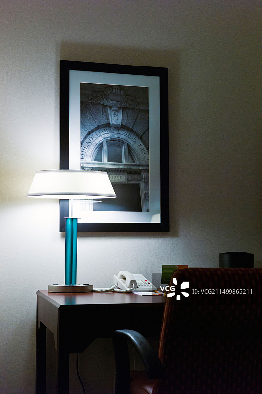 高档酒店房间的夜晚：书桌、台灯和椅子图片素材