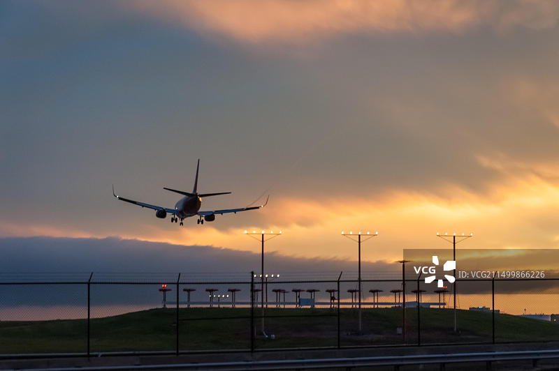 亚特兰大国际机场一架客机在火红的日落下着陆（美国佐治亚州亚特兰大）图片素材