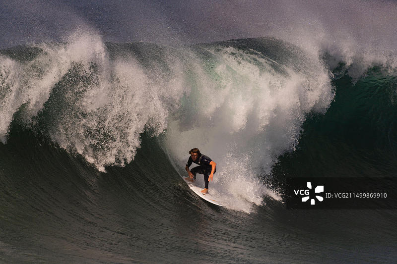 男子在美国加利福尼亚州纽波特海滩冲大浪图片素材