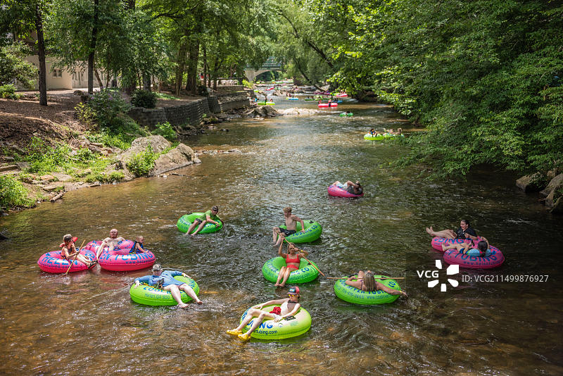 家庭在佐治亚州海伦市中心的查塔胡奇河中享受漂流的夏日图片素材