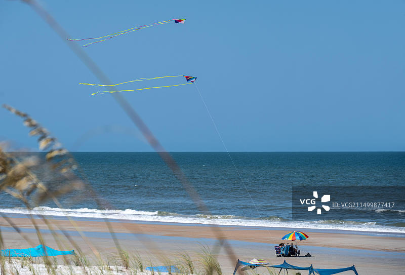 年长的夫妇在佛罗里达州圣奥古斯丁海滩的彩色遮阳伞下享受美好的一天（美国）图片素材