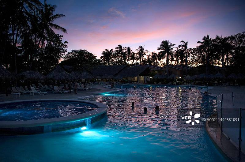 在哥斯达黎加塔马林多，中美洲，人们在游泳池里观看日落图片素材