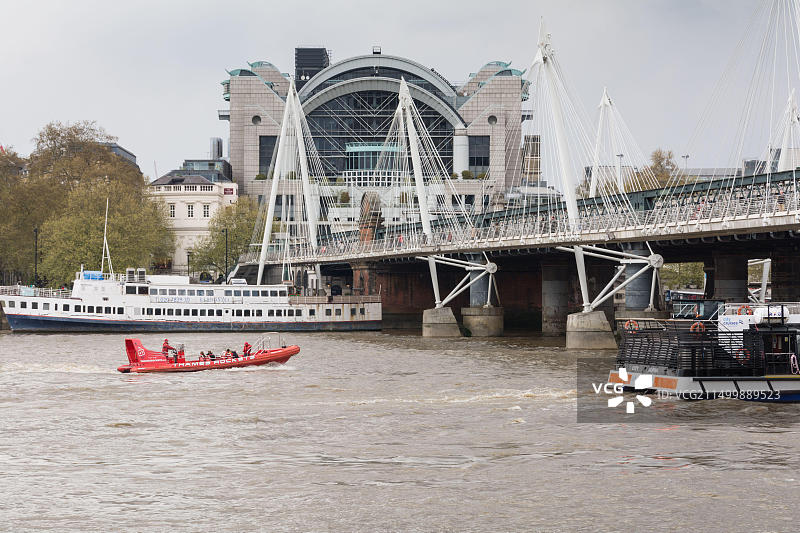 泰晤士火箭快艇驶过查令十字车站、金禧桥和亨格福德桥，伦敦，英国图片素材