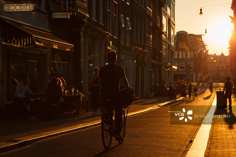 阿姆斯特丹日落时分，轮廓光照亮的自行车骑行者图片素材