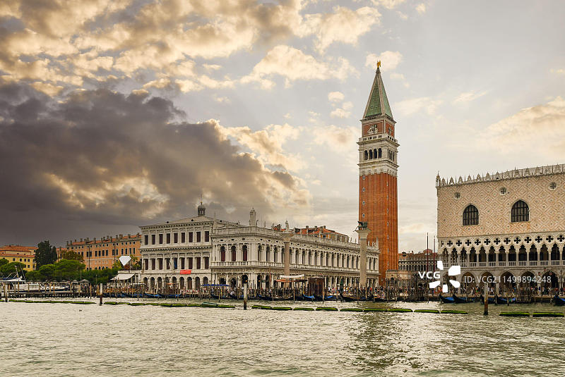 日落时分，从圣马可盆地眺望圣马可广场，左侧是马尔恰纳图书馆，还有钟楼和总督宫，意大利威尼托图片素材