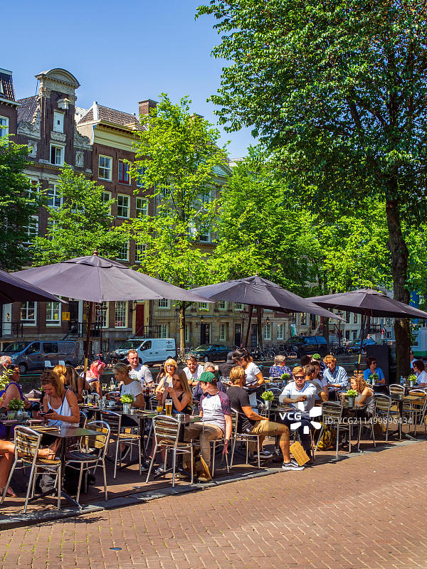 在荷兰阿姆斯特丹运河旁的咖啡馆露台上的人们图片素材