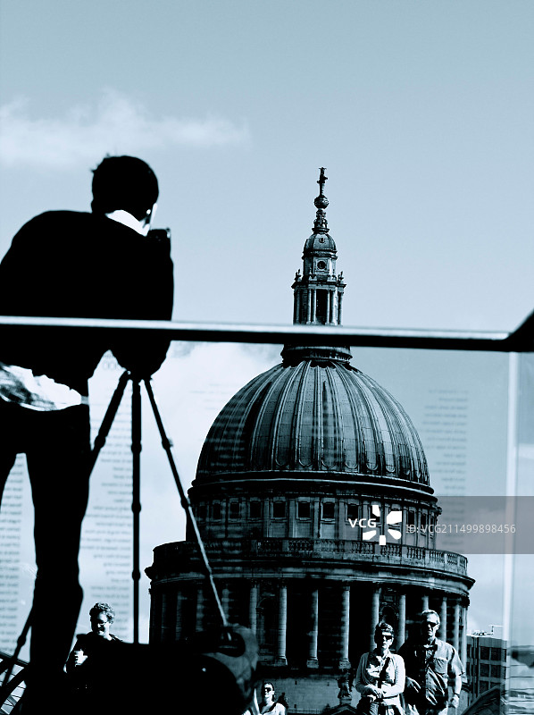 游客走过伦敦千禧桥，摄影师用三脚架拍摄圣保罗大教堂图片素材