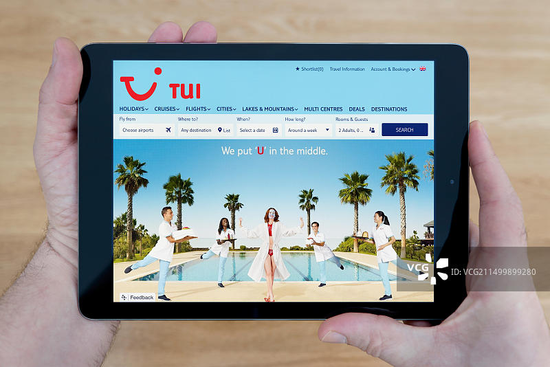 男人用iPad平板电脑看TUI网站图片素材