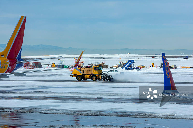 科罗拉多州丹佛：丹佛国际机场，一辆扫雪机正在清理西南航空飞机旁的滑行道图片素材