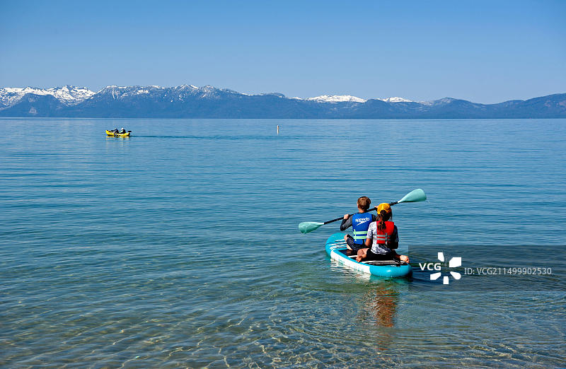 孩子们在加州太浩湖清澈的湖水中划充气筏图片素材