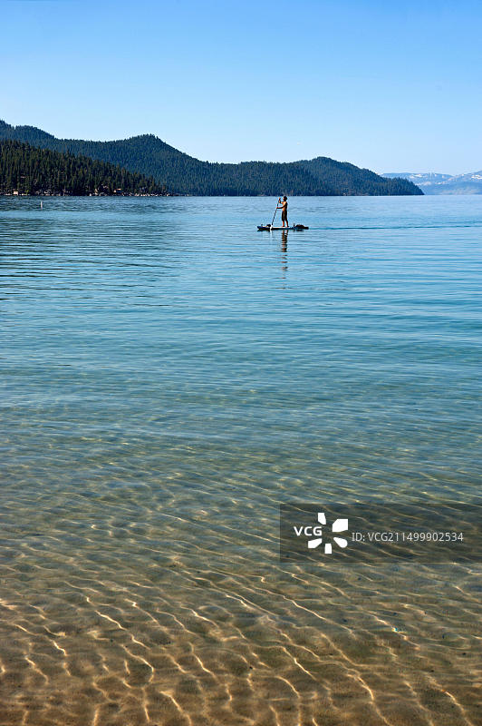 在加利福尼亚州太浩湖沙港玩桨板的男人图片素材