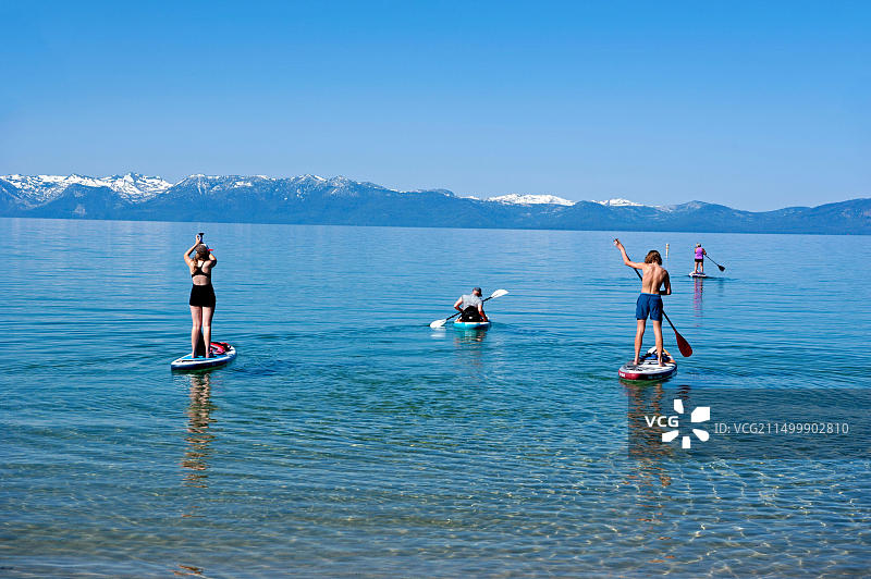 在加利福尼亚州太浩湖上划桨板的人们图片素材