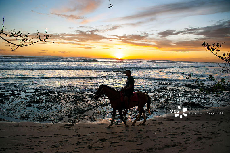 在哥斯达黎加海滩上骑马的人图片素材