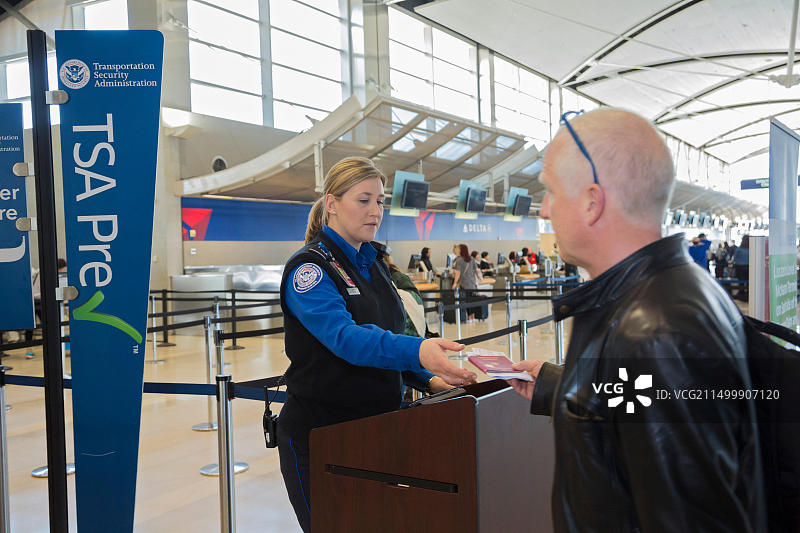 密歇根州罗马ulus：底特律都会机场的运输安全管理局官员检查乘客身份图片素材