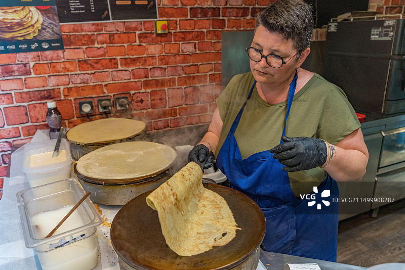 在法国诺曼底圣米歇尔山制作可丽饼的女人图片素材
