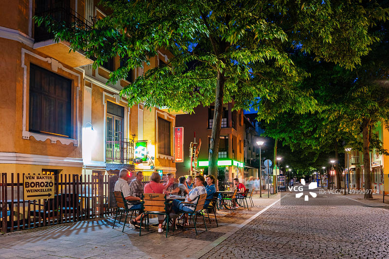 人们在匈牙利黑维兹市中心的一家餐厅酒吧露台上享受夜晚图片素材