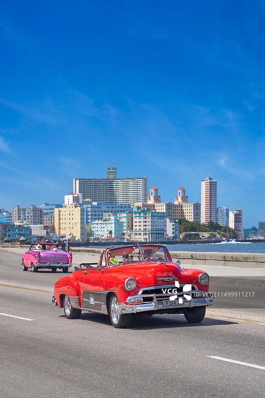 在古巴哈瓦那马雷贡大道上行驶的旧红色汽车图片素材