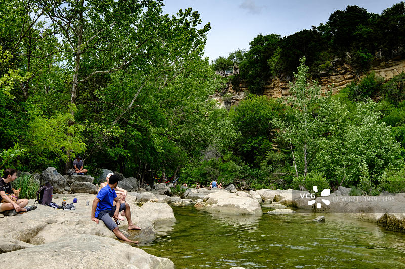 游客在德克萨斯州奥斯汀的巴顿 Creek Greenbelt 放松身心，享受春日天气图片素材