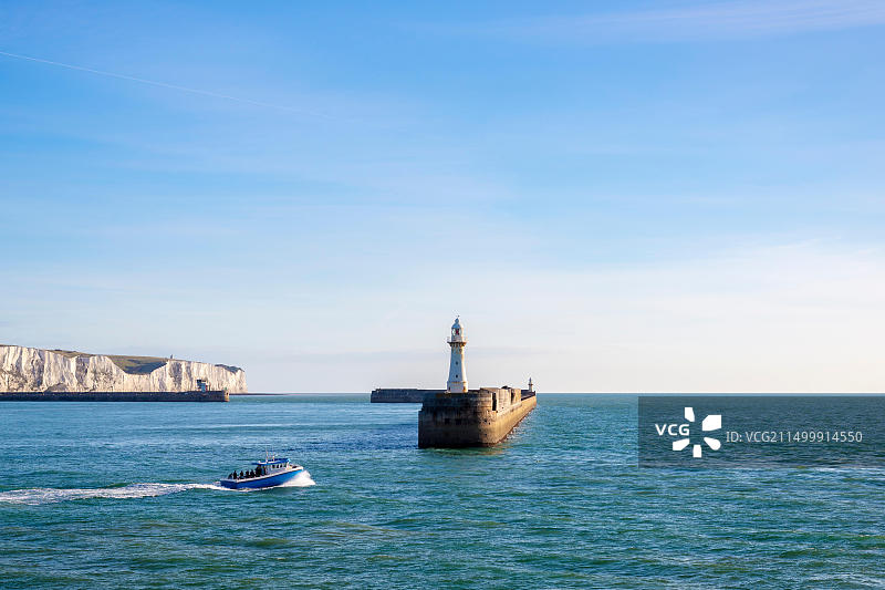 一艘渔船离开多佛港，背景是标志性的白色悬崖图片素材