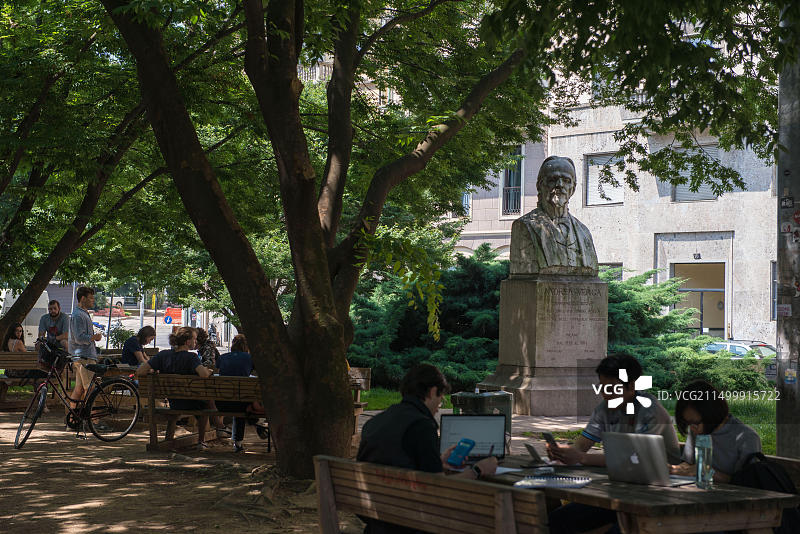 米兰：在花园里、安德烈·韦尔加雕像附近学习的年轻人图片素材