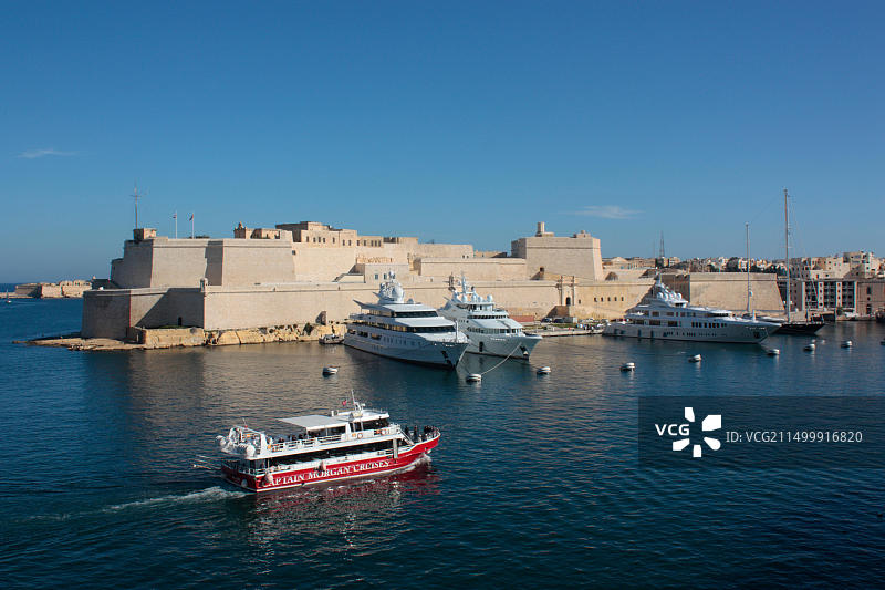 游船途经马耳他圣安吉洛堡，游客在船上观光。旅游业是马耳他的重要经济部门。图片素材