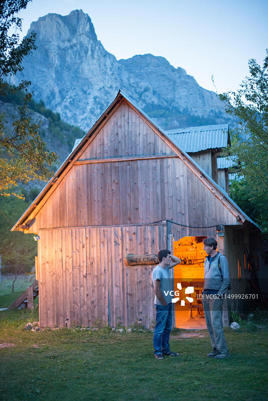 阿尔迪特和蒂姆在暮色中于餐厅外交谈图片素材