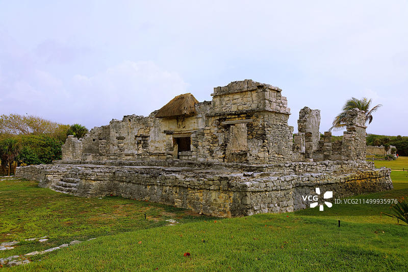 下降神庙正面，主门上方雕刻着倒立的人物，背景是淡蓝色的天空图片素材