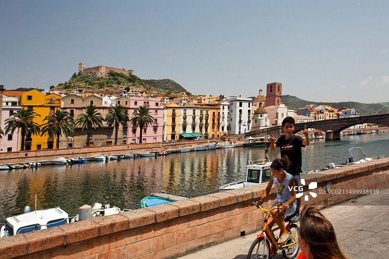 意大利撒丁岛博萨西海岸运河儿童骑自行车图片素材