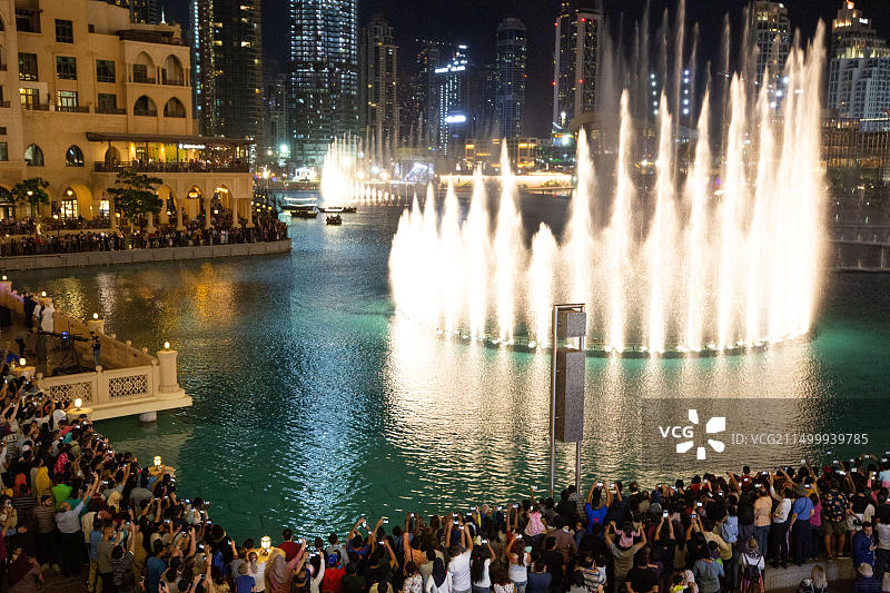 迪拜购物中心壮观的喷泉表演吸引了人群，阿联酋图片素材