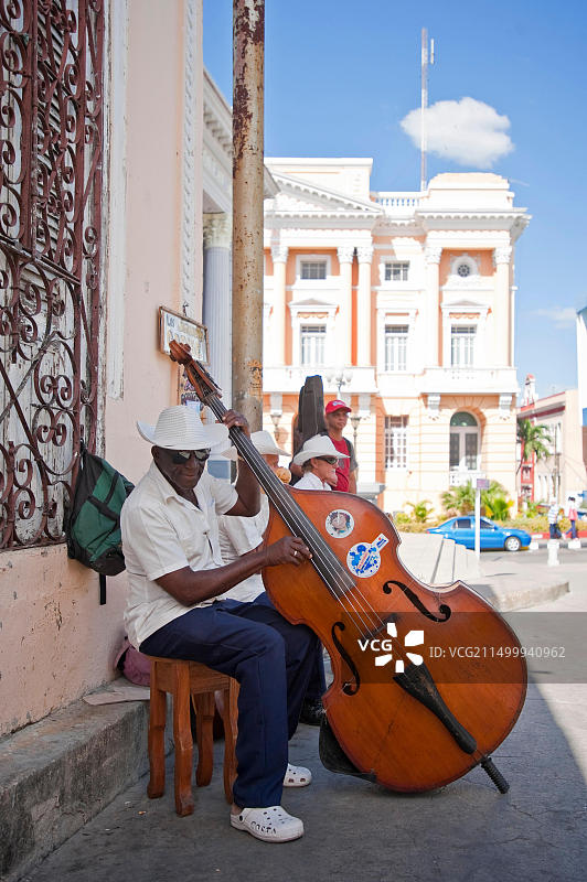 古巴圣地亚哥街头典型的萨尔萨乐队卖艺场景竖版照片图片素材