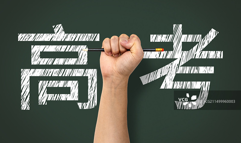 手握铅笔背后的黑板写着高考图片素材