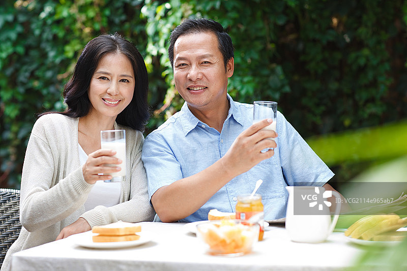 中年夫妇在院子里吃早餐图片素材