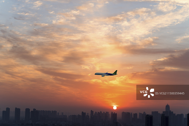 彩霞满天，飞过城市上空的C919客机图片素材