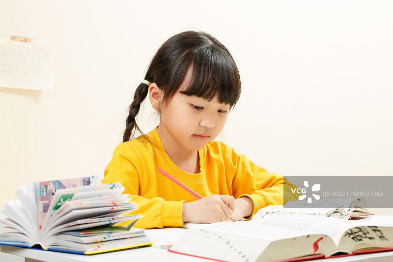 室内学习桌前写作业的中国小女孩图片素材